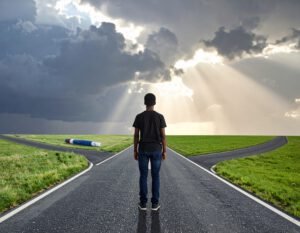 Ein junger Mensch steht an einem Kreuzweg in einer dramatischen Landschaft, bereit, seinen Blutzucker zu managen.