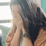Eine Person hält sich verzweifelt das Gesicht, möglicherweise aufgrund von Hypo- oder Blutzuckerproblemen. | © GlucoseCode